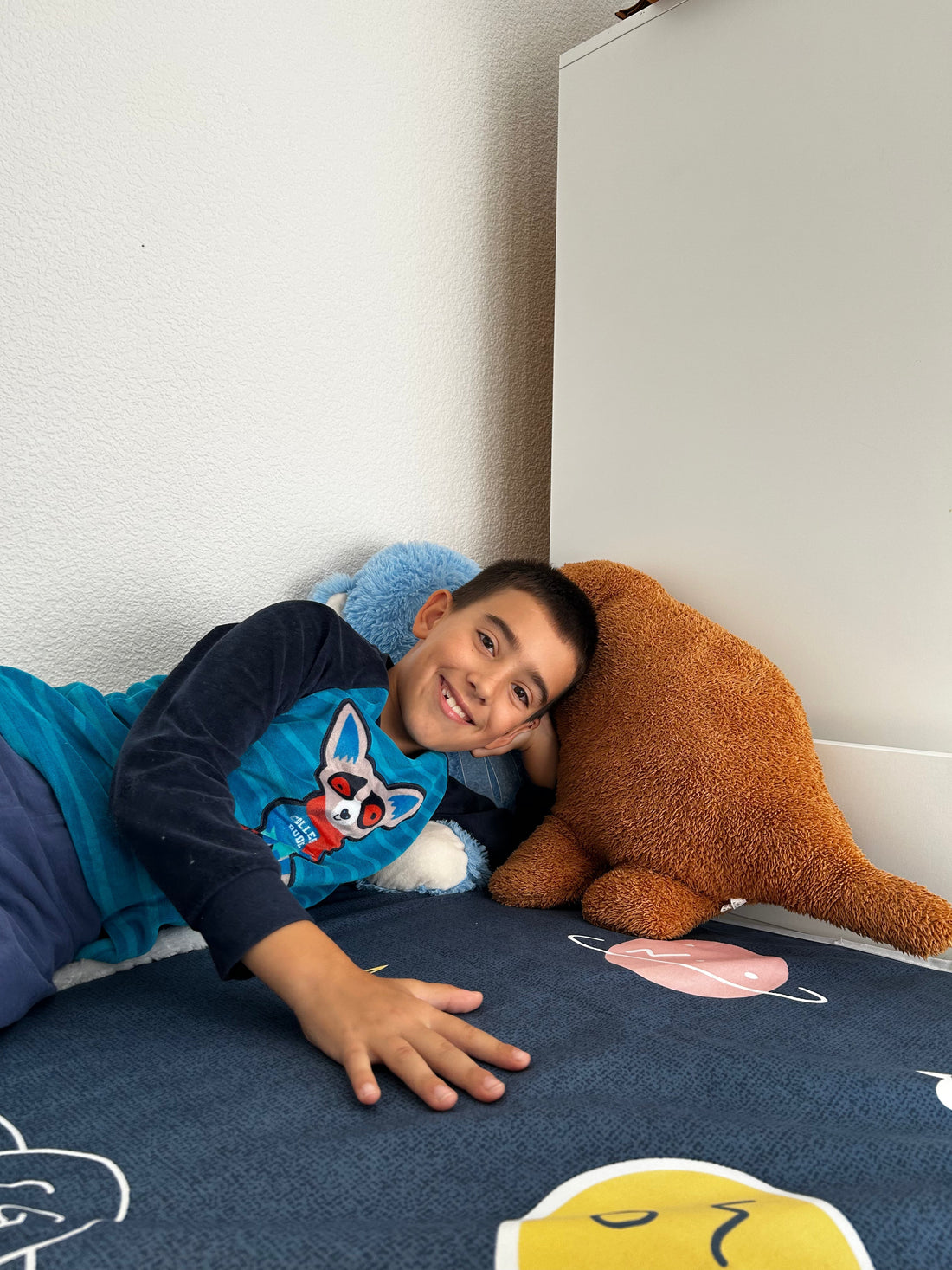 Lächelnder Junge liegt entspannt auf dem Sofa